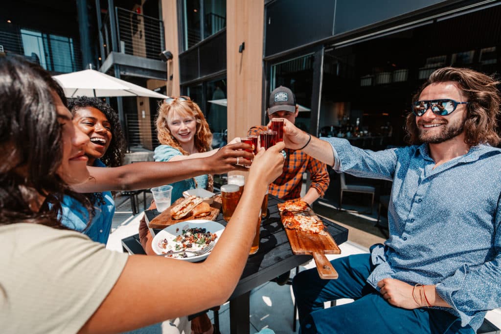 Party of 5 enjoying food and drinks at outdoor seating