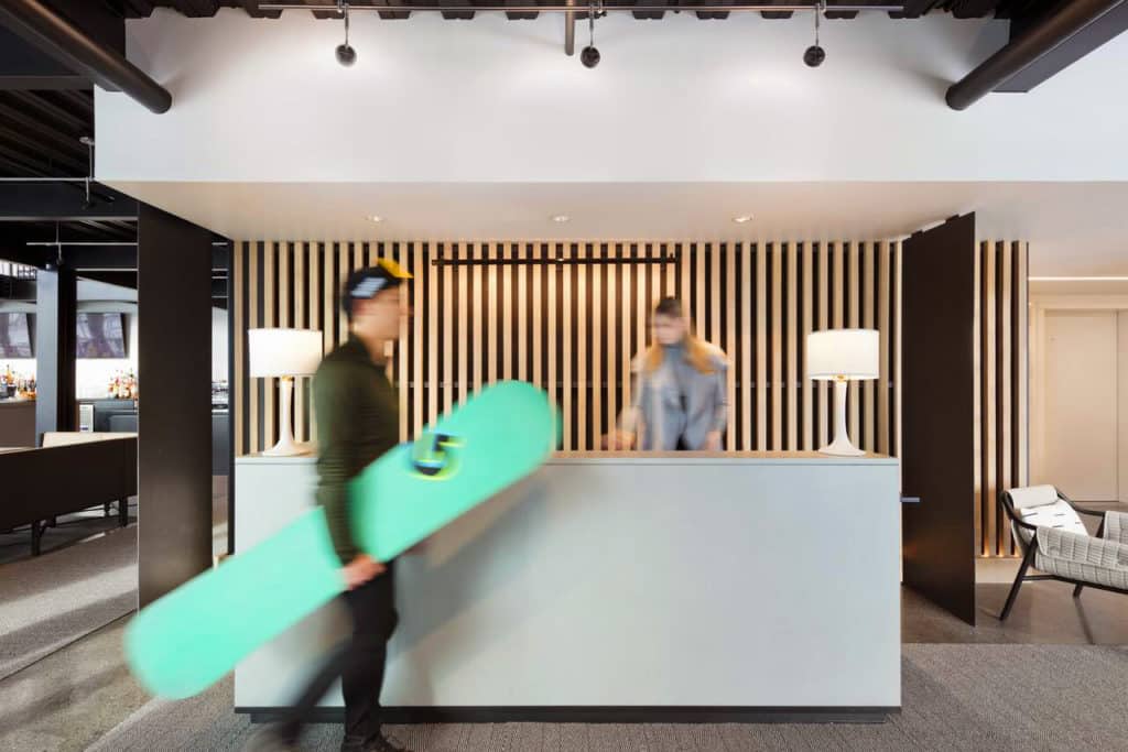 Snowboarder walking by the front desk