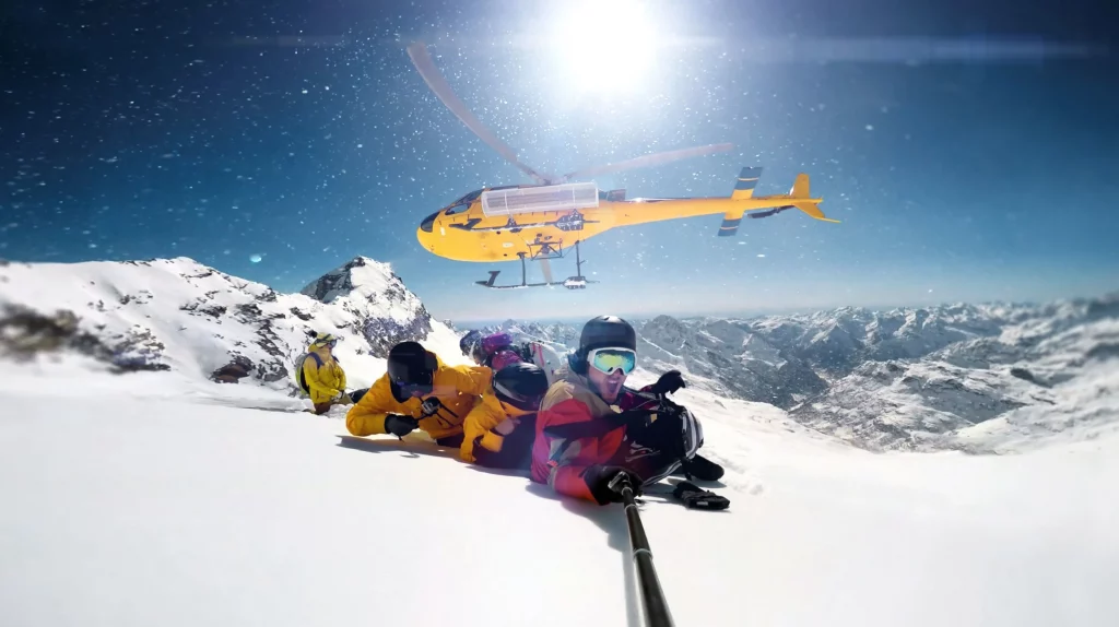helicopter dropping off skiers at the top of a mountain